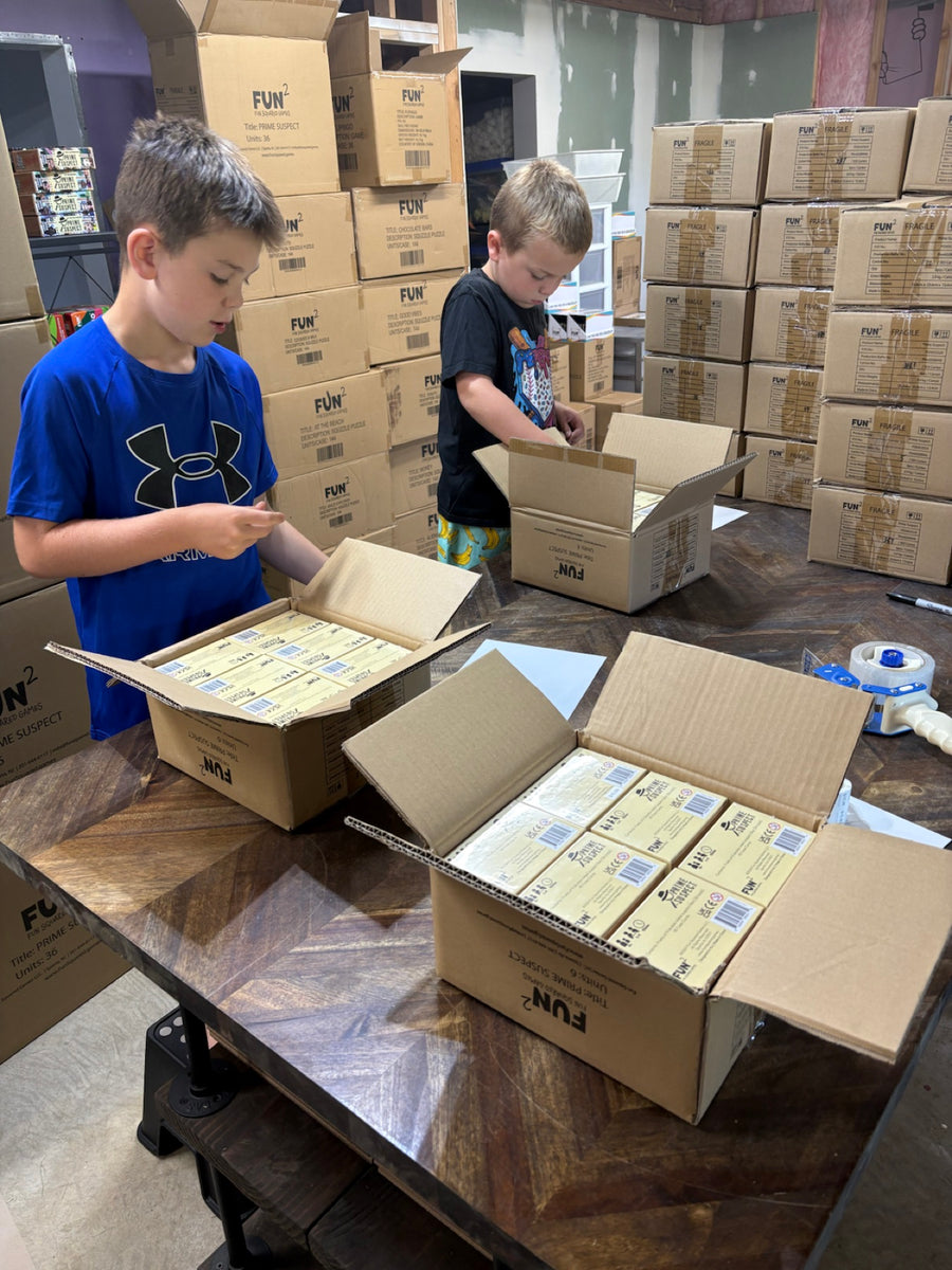 Two of the Fun Squared kids packing games in the family warehouse